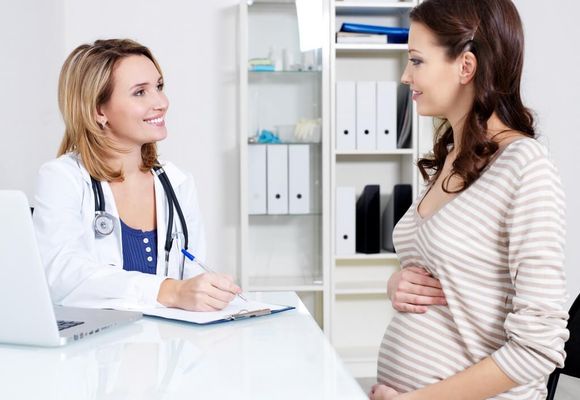 беременная разговаривает с врачом